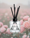 Belbora candle co Under the stars reed diffuser with black sticks against a blurred floral background